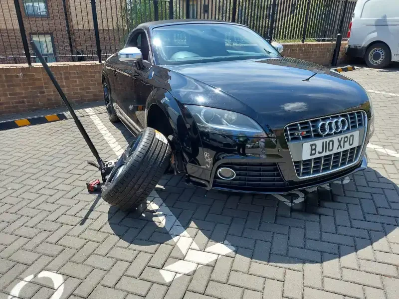 Expert technician performing non-destructive mobile locking wheel nut removal service on a vehicle across Beds, Bucks, and Herts.